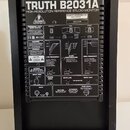 Zadní strana černého studiového monitoru s nápisem TRUTH B2031A HIGH-RESOLUTION REFERENCE STUDIO MONITOR. Na štítku je uvedena značka BEHRINGER, mode…