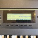 Detailní záběr na ovládací panel a displej klaviatury. Na LCD displeji je zobrazeno menu ProgramMode s vybranou položkou Grand Piano a seznamem zvuků…