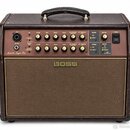 Hnědý akustický zesilovač s látkovou mřížkou a koženým úchem. Na předním panelu je nápis Acoustic Singer Pro a v centru mřížky logo BOSS. Ovbední pan…