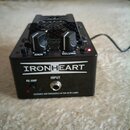 Černý kytarový efekt s nápisem IRONHEART. Na horní straně jsou dva ovládací knoflíky s popisky GAIN a VOLUME, přepínač ON/OFF a červená kontrolka. Na…