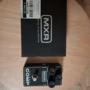 Černý kytarový efekt pedál s nápisem Super COMP a logem MXR. Na horní straně jsou tři ovládací knoflíky s popisky OUTPUT, ATTACK a SENSITIVITY. Vedle…