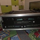 V hliníkovém transportním kufru jsou umístěny tři rackové jednotky. Horní zařízení má nápis Great American Sound GAS-8000 VHF WIRELESS RECEIVER. Pod…