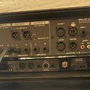 Zadní strana černého rackového zařízení s nápisem FRACTAL AUDIO SYSTEMS. Panel obsahuje různé vstupy a výstupy, včetně sekcí INPUT 1, INPUT 2 FX RETU…