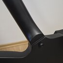 Detailní záběr na spojení krku a těla černé kytary s matným povrchem. Na těle je vidět jeden zapuštěný šroub. Povrch nástroje vypadá čistě a bez vidi…