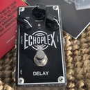 Černý efekt pedál s nápisem ECHOPLEX a DELAY. Na horní straně jsou tři černé otočné ovnovky s popisky GAIN, VOLUME a AGE. V dolní části je umístěn ko…