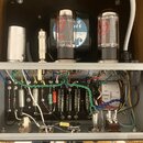 Fotografie zachycuje vnitřek elektronického zařízení, pravděpodobně zesilovače, s dvěma elektronkami a rozsáhlým zapojením komponentů v kovovém šasi.…
