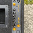 Černý basový zesilovač s ovládacím panelem, na kterém je žlutý nápis Little Mark 250 Black Line a logo Markbass. Panel obsahuje několik žlutých otočn…