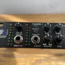 Černý rackový zesilovač sluchátek s nápisem HEAD AMP 6 PRO a popiskem PROFESSIONAL SIX CHANNEL HEADPHONE AMPLIFIER WITH EQ AND AUXILIARY MIXER. Na př…