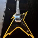 Elektrická kytara s černým bodies a žlutými okraji v tvaru hvězdy, umístěná v černém kufru. Na hlavě je viditelné logo ESP. Kytara má dva humbuckery,…