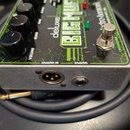 Kytarový efekt pedál v kovovém šasi s černým povrchem a zelenými grafickými prvky. Na horní straně jsou nápisy „deluxe bass“, „BIG MUFF“ a logo „elec…