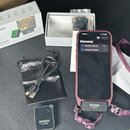 Sada bezdrátového mikrofonu značky SYNCO, obsahující vysílač s nápisem SYNCO Transmitter a přijímač s nápisem SYNCO Receiver připojený k telefonu. So…