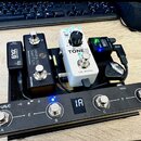 Sada kytarových efektů a ovládacích pedálů na černém podložkovém boardu. V popředí je černý pedalboard M-VAVE s čtyřmi spínači označenými A, B, C a D…