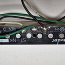 Černý snímač k elektrické kytáře s šesti polkovými magnety. Na spodní straně je bílý nápis „ST-NK“, nápis „REV. D“ a označení „CE 3-0“. V pravé části…
