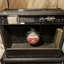 Zadní strana kytarového komba značky Marshall s nápisem VALVE STATE. Uvnitř je viditelný reproduktor s logem CELESTION a červeným štítkem s nápisem A…
