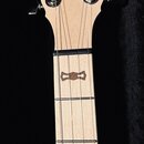 Hrabedno světle dřevěného nástroje s nápisem GOODTIME na hlavě a textem Made with Pride in the USA pod hvězdicí. Hmatník je světlý s tmavými ozdobným…