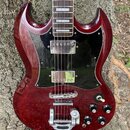 Tmavě červená elektrická kytara s černým plechtem. Nástroj má dva humbuckery, tři ovládací knoflíky a jeden přepínač. Na těle nejsou viditelné žádné…