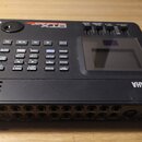Černý elektronický bicí modul značky YAMAHA s displejem a ovládacími tlačítky. Na horní hraně je nápis DTX s nečitelným označením modelu. Zadní stran…