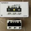 Fotografie zobrazuje kytarový efektový pedalboard PLETHORAX3 značky tc electronic, který leží před svým původním kartonem. Zařízení je bílé s černým…