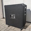 Černý basový reproduktor v kostce potažený látkovým povrchem s kovovými rohy a madlem na boku. Na zadní straně je ovládací panel s nápisem agilar a n…