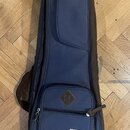 Modrý softcase na hudební nástroj s hnědými detaily a popruhem. V dolní části je bílá štítková nálečka s nápisem „Power Pad“ a pod ní textem „DESIGNE…