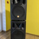 Dvě černé reproduktorové bedny umístěné jedna na druhé. Každý reproduktor má v horní části rohnový membránový hovorník a ve spodní části velký basový…