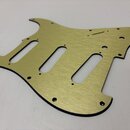 Zlatý kovový pickguard pro elektrickou kytaru s třemi výřezy pro snímače. Povrch má jemnou broušenou texturu a v horní části je úzký slot pro přepína…