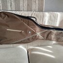 Hnědý softcase na kytaru s černým zipem a úchytkem. Na přední straně je bílý nápis RITTER a malý trojúhelníkový štítek s nápisem RITTER. Povrch texti…