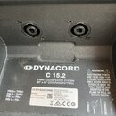 Záběr na zadní část černého reproduktoru s dvěma konektory. Na bílém štítku je uveden název DYNACORD a model C 15.2, s popisem 2-WAY LOUDSPEAKER SYST…