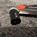 Černý XLR konektor s modrým plastovým prstencem v horní části. Na boku konektoru je bílý nápis STUDIOSPARES s logem. Vedle konektoru leží černé balen…