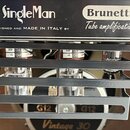 Detailní záběr na zadní část zesilovače s nápisy SingleMan a Brunetti Tube amplification, pod kterým je text DESIGNED AND MADE IN ITALY BY. V popředí…