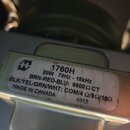Detail kovového komponentu s bílou nálepkou. Na nálepce je logo ve tvaru stylizedého písmena M a text: 1760H, 20W 70Hz - 15KHz, BRN-RED-BLU: 6600 Ω C…