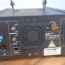 Černý laserový projektor s ovládacím panelem. Na zadní straně jsou nápisy DMX 512, DMX ADDRESS, BLANKING SWITCH, K/Y SWITCH a PC SIGNAL, dále jsou zd…