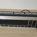 Digitální grafický ekvalizér v rackovém provedení s kovovým šasi. Na horní části je nápis ULTRAGRAPH DIGITAL DEQ1024 a pod ním text ULTRA-MUSICAL 31-…
