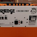 Zadní strana kytarového komba v oranžovém provedení s bílým zadním panelem. Na panelu je velký nápis ORANGE a model CRUSH 35RT spolu s grafickým loge…