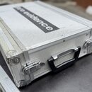 Stříbrný hliníkový kufr s texturovaným povrchem a kovovými hranami. Na víku je černý nápis pro evidence. Kufr má černé plastové madlo a dvě kovové zá…