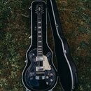 Kytara s tmavě modrým lakem a bílým pickguardem v černém tvrdém kufru. Na hlavě hmatníku je bílé logo „Epiphone“. Nástroj má dva humbuckery, čtyři ov…
