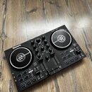 Černý DJ 컨트롤러 značky Numark s nápisem PARTY MIX. Zařízení obsahuje dva stříbrné jog-wheels, několik otočných knoflíků a posuvníky. Povrch je v dobrém…