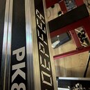 Detailní záběr na černý klavír nebo syntezátor s hliníkovými lištami. Na černém povrchu je bílý nápis PK88 a vedle něj vertikální bílý nápis KOEREE.…