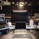 Fotografie zachycuje pracovní místo s hudební technikou. Jsou zde dva studiové monitory značky FOCAL, notebook, externí klávesnice a myš. V popředí j…