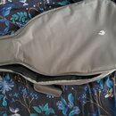 Šedý softcase na kytaru z textilního materiálu. Na přední straně je umístěno bílé logo ve tvaru stylizovaného písmena C. Povrch je v dobrém stavu, be…