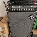 Snímek zobrazuje stoh hudebního vybavení. V horní části jsou tři rackové jednotky: černý přístroj s nápisem KORG, pod ním zařízení SAMSON PowerBrite…