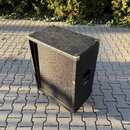 Černý basový reproduktor v hranatém kufru potaženém černou texturou. Rohy jsou chráněny kovovými prvky a na boční straně je umístěna rukojeť. Na před…