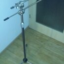 Kovový mikrofonní stativ s tříramennou základnou. Stativ má teleskopický hlavní sloup a dvě nastavitelné ramena s úklopovými knoflíky. Povrch je v st…