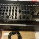Černý syntetizátor Roland SYNTHESIZER SH-4d s velkým množstvím otočných knoflíků, posuvníků a ovládacích prvků. Na přední straně je viditelné logo Ro…