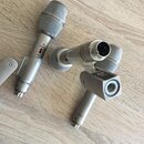 Tři stříbrné mikrofony s kovovým povrchem a šedými mřížkami. Na jednom z nich je viditelný nápis D124 C a červený proužek. Druhý mikrofon je zobrazen…