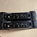 Dvě identické černé DI boxy značky PROEL s nápisem DB1•P PASSIVE D.I.BOX. Na přední straně se nacházejí konektory INPUT, LINK a BAL OUTPUT, přepínače…