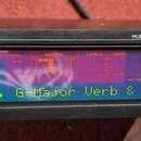 Černý kytarový procesor s nápisem electronic a označením GUITAR PROCESSOR. Zařízení má Multi Spectral LCD Display, na kterém je zobrazen text G-Major…