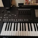 Černý digitální klavír značky YAMAHA. Nástroj má ovládací panel s mnoha tlačítky, posuvníky a displejem. Na klávesnici jsou bílé a černé klávesy v do…