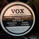 Fotografie zachycuje zadní stranu reproduktoru s kovovým magnetem. Na štítku je uveden nápis VOX AMPLIFICATION Ltd, CUSTOM LOUDSPEAKER SERIES a MODEL…