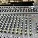 Šedý mixovací pult s nápisem SPIRIT FOLIO by Soundcraft. Horní část obsahuje řadu vstupních konektorů a přepínačů, v pravé části je nalepená bílá nál…